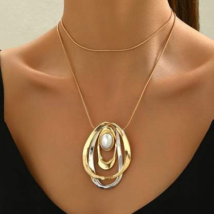 Close-up of the pearl and overlapping ovals on the neckline