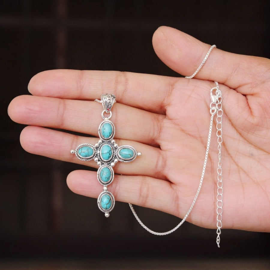 Bohemian Turquoise Cross Necklace held in hand