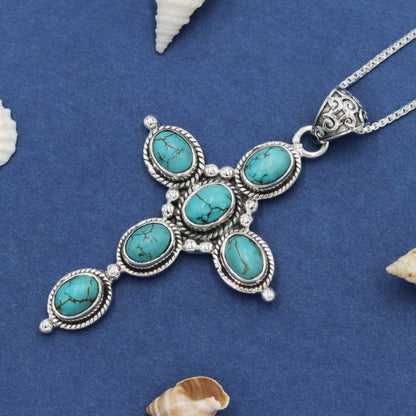 Bohemian Turquoise Cross Necklace on blue fabric
