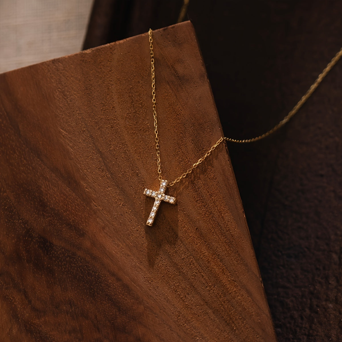 Refined Mini Cross Necklace styled on a wood board