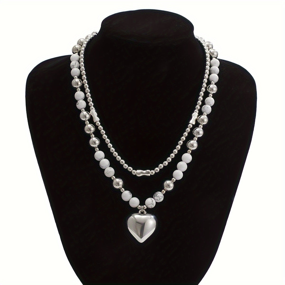 Both necklaces displayed on a stand