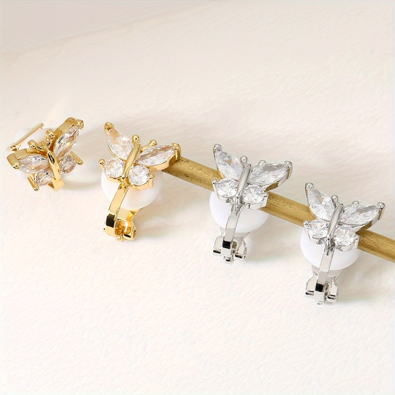 Golden and silver butterfly clip earrings side by side