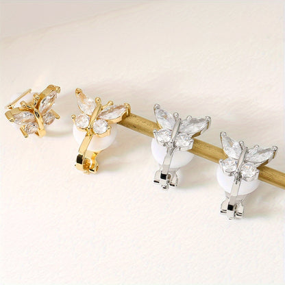 Golden and silver butterfly clip earrings side by side